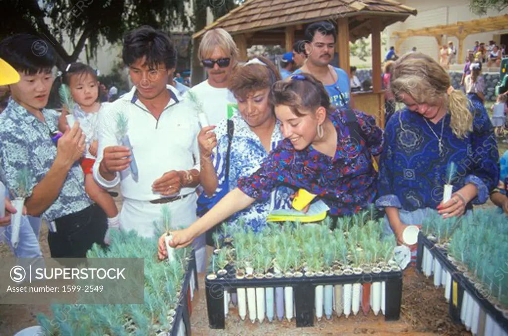 A group of people examining tree seedlings at a booth at the 1991 Los Angeles County Fair 