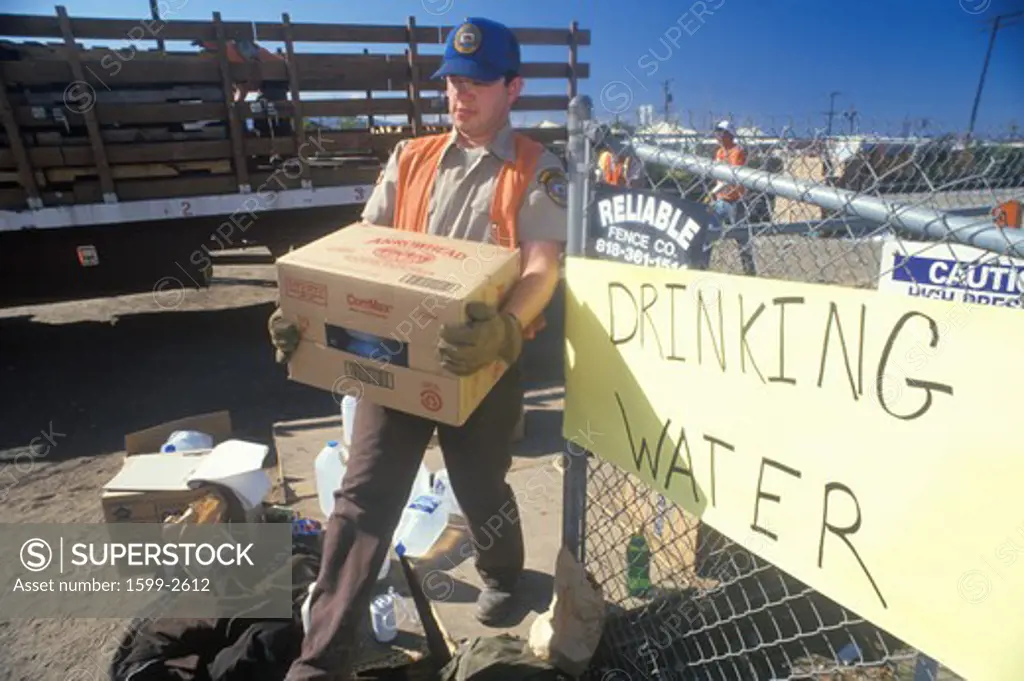 A man carrying drinking water away from a relief station in Santa Clara after the 1994 earthquake 
