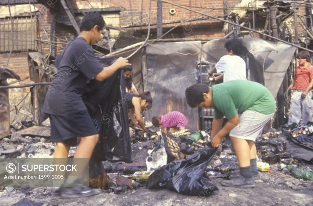 Family rummaging through home burned during riots, South Central Los Angeles, California