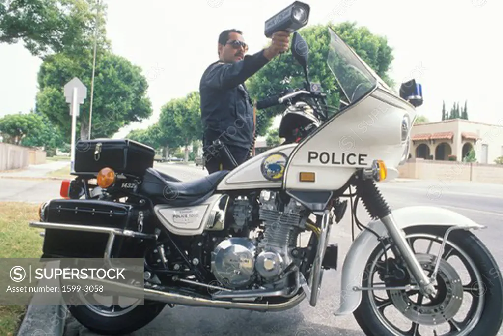 Traffic motorcycle cop pointing radar gun, Santa Monica, California