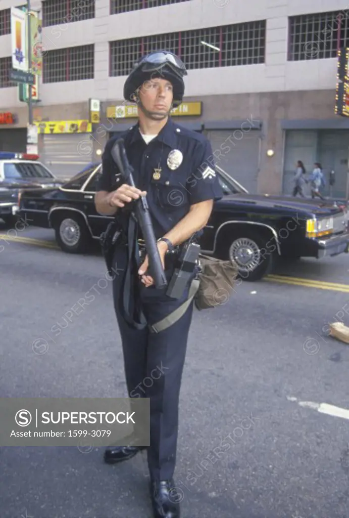 Police in riot gear holding weapon, downtown Los Angeles, California