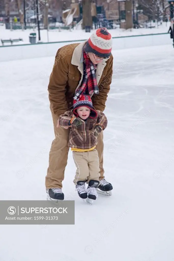 Father teaches son to skate at Boston Common Ice Skating Rink and Frog Pond, Boston, MA., New England, USA