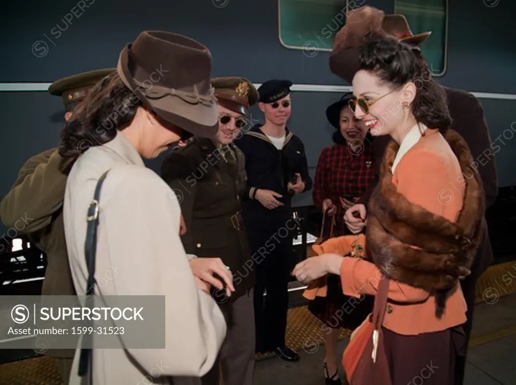 Two 1940's female reenactors laugh before boarding Pearl Harbor Day Troop train reenactment from Los Angeles Union Station to San Diego