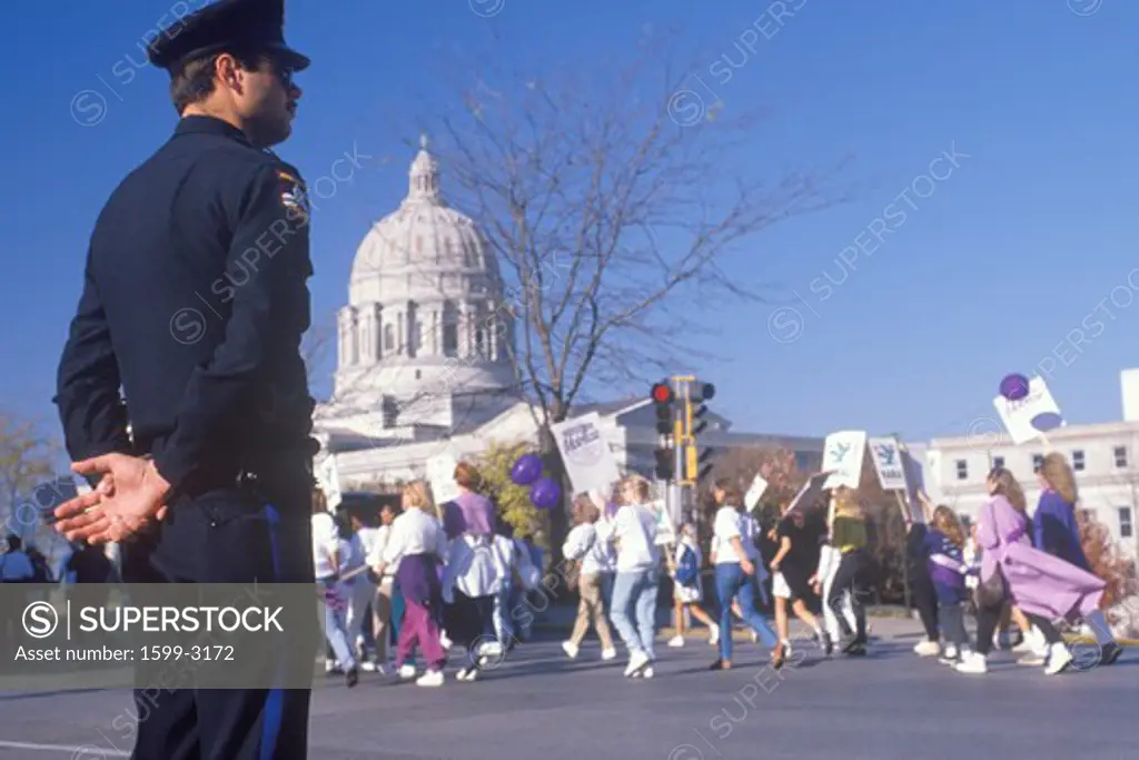 Police officer observing pro-choice march at State Capitol Building, Missouri