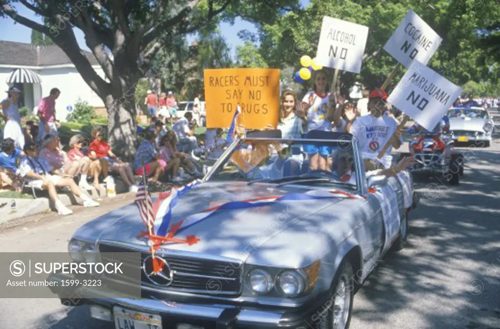 Activists riding in car with signs during anti-drug community parade, Pacific Palisades, California