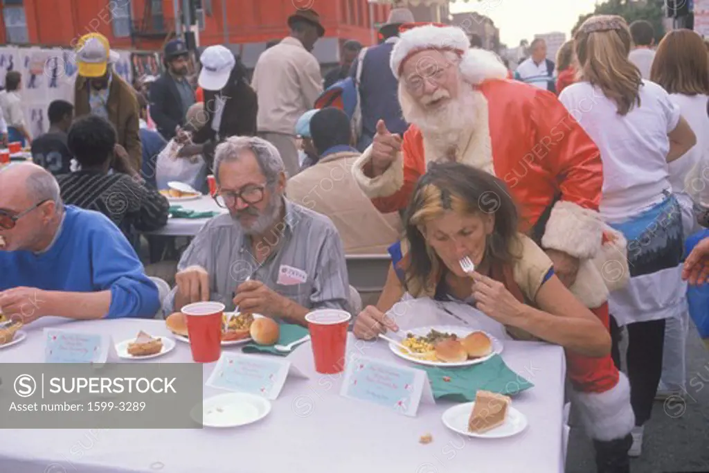 Santa Claus posing with the homeless for Christmas dinner, Los Angeles, California