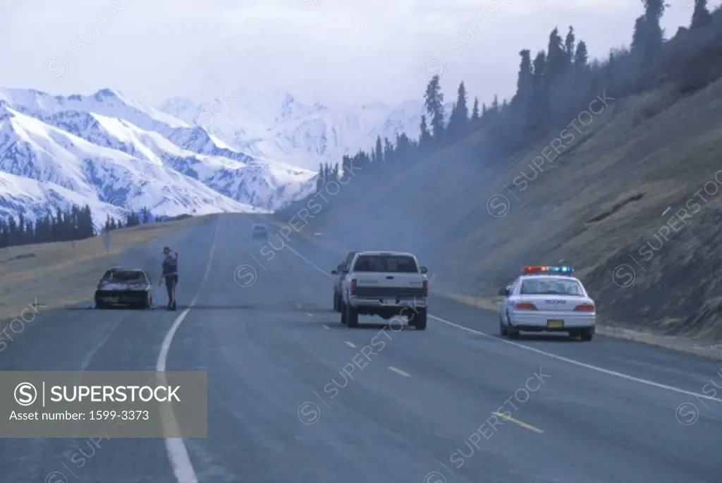 Highway patrolman and car on fire, Alaska