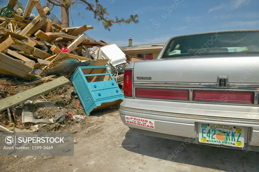 Proud to be an American bumper sticker and debris in front of house heavily hit by Hurricane Ivan in Pensacola Florida