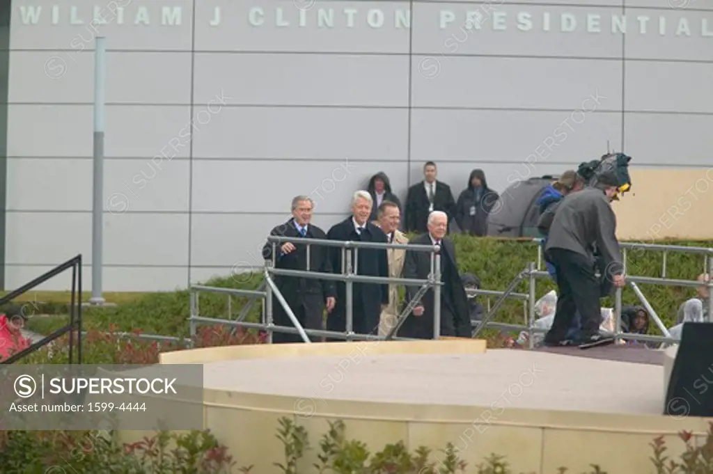 Former U.S. President Bill Clinton approaches the stage with President George W. Bush, former presidents Jimmy Carter and George H. W. Bush during the official opening ceremony of the Clinton Presidential Library November 18, 2004 in Little Rock, AK