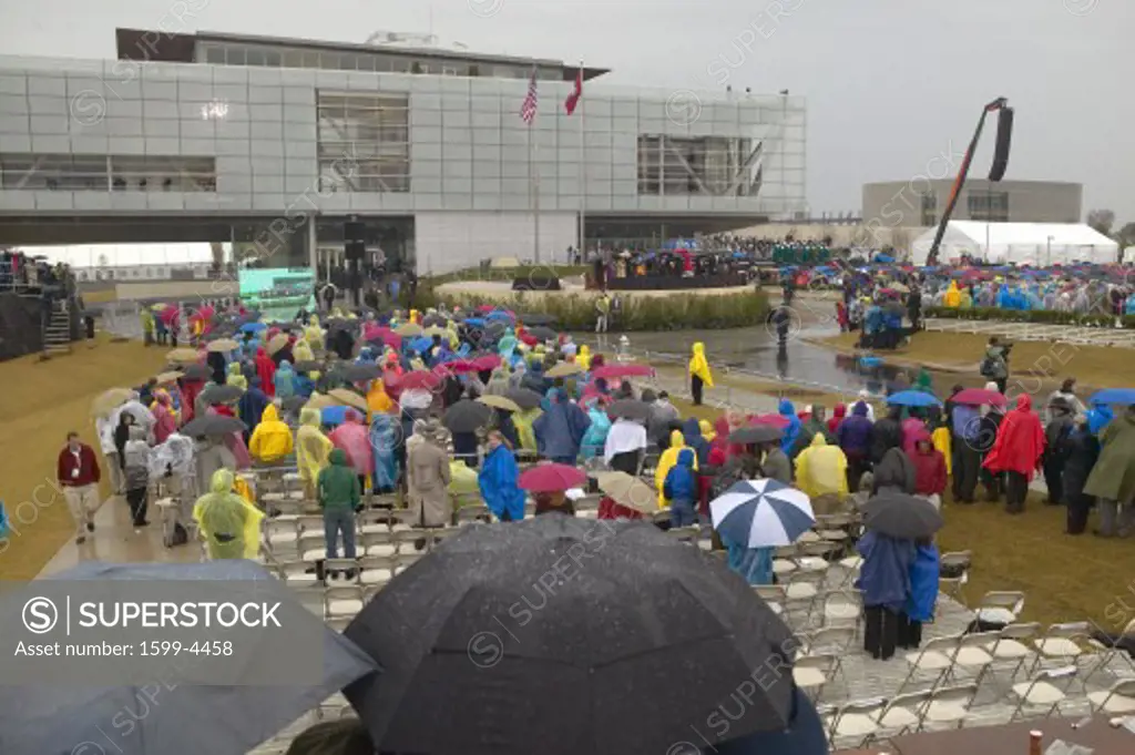 Guests hold umbrellas in the rain as they attend the official opening ceremony of the Clinton Presidential Library November 18, 2004 in Little Rock, AK