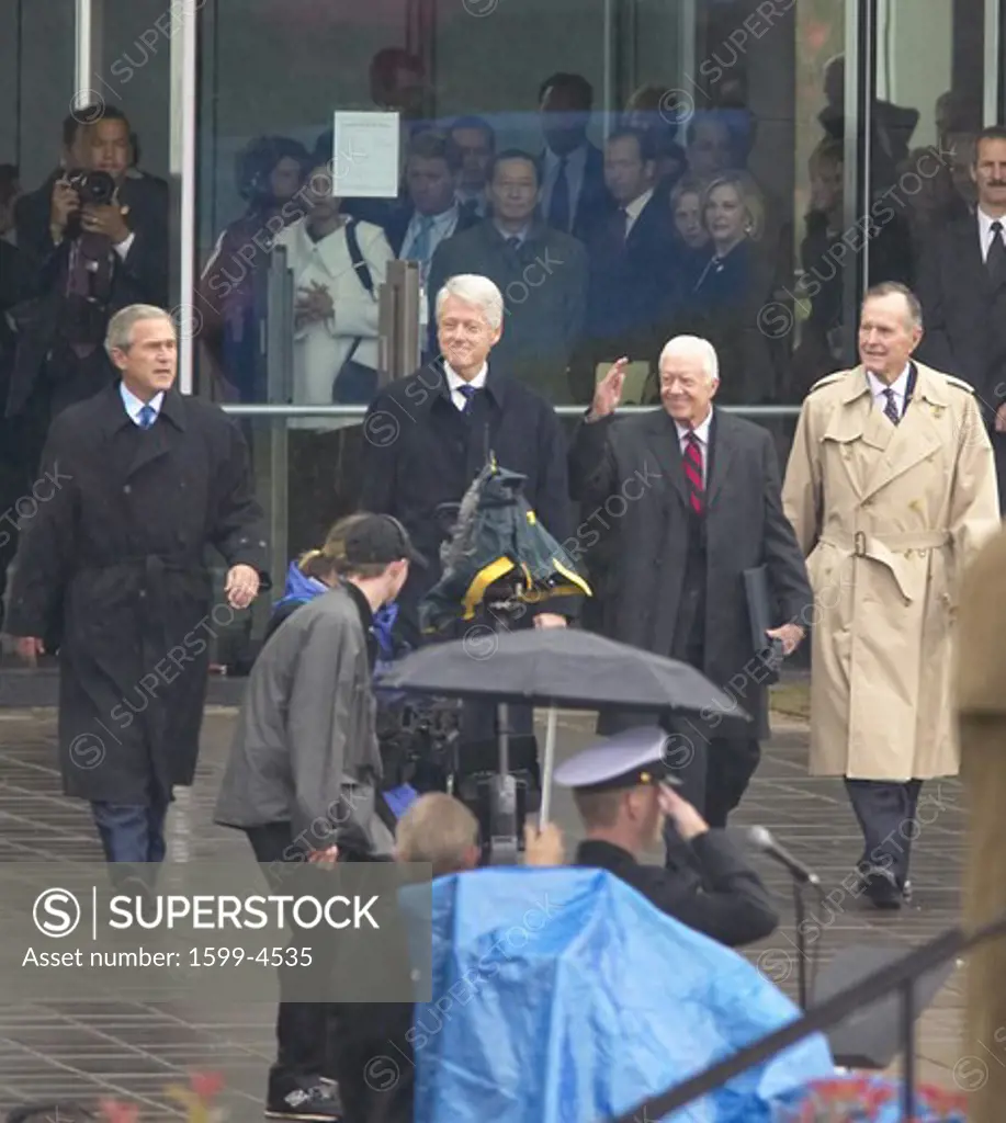 Former U.S. President Bill Clinton emerges from the library with President George W. Bush, former presidents Jimmy Carter and George H. W. Bush during the official opening ceremony of the Clinton Presidential Library November 18, 2004 in Little Rock, AK