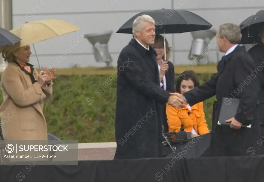 Former US President Bill Clinton shakes hands with US President George W. Bush during the grand opening ceremony of the William J. Clinton Presidential Center in Little Rock, AK 18 November 2004.