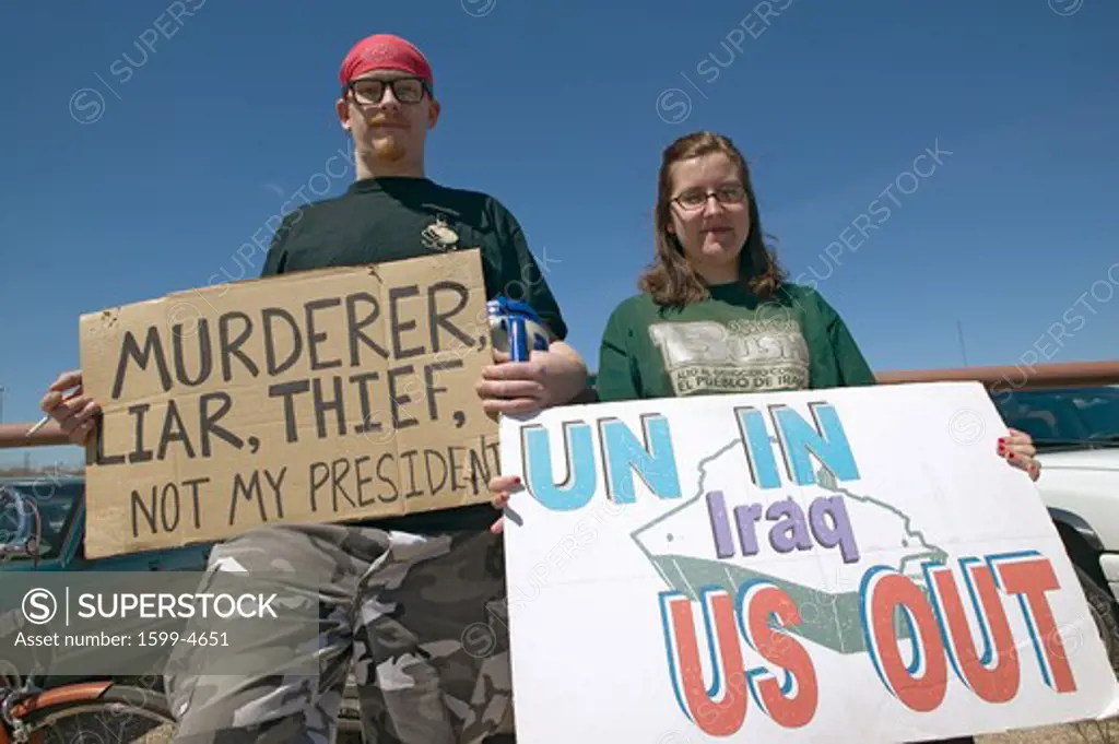 Three protestors in Tucson, AZ of President George W. Bush is holding a sign proclaiming Bush is a Liar and US Out regarding the Iraq War