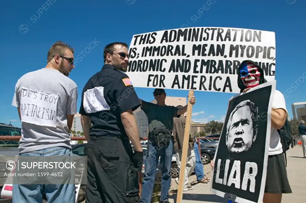 Three protestors in Tucson, AZ of President George W. Bush is holding a sign proclaiming Bush is a Liar regarding the Iraq War