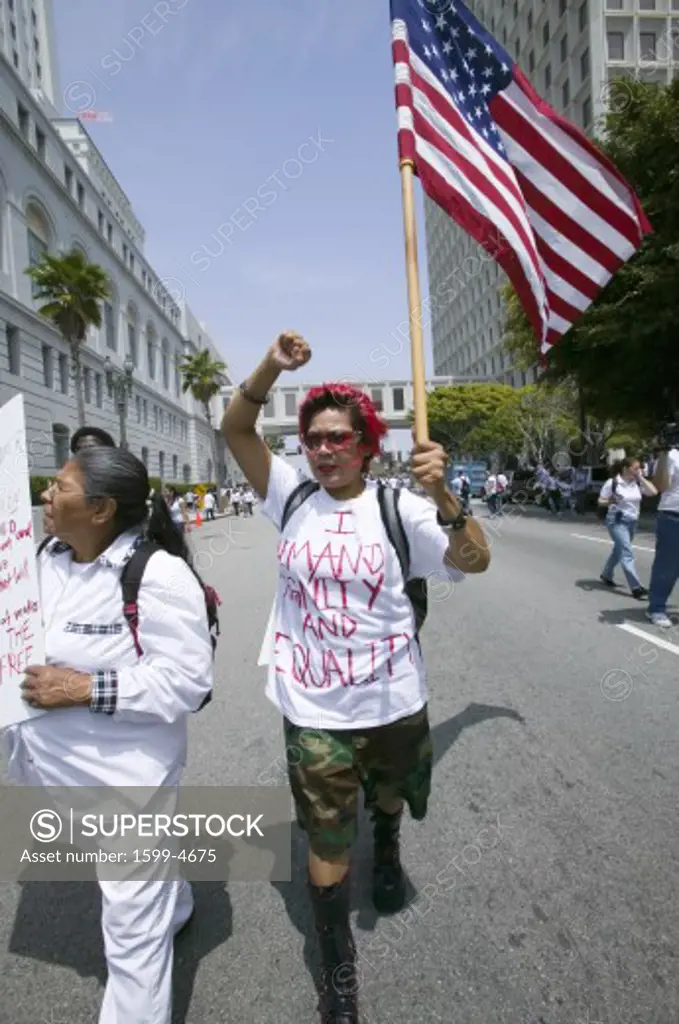 Protestor carries US flag demanding equality with hundreds of thousands of immigrants participating in march for Immigrants and Mexicans protesting against Illegal Immigration reform by U.S. Congress, Los Angeles, CA, May 1, 2006