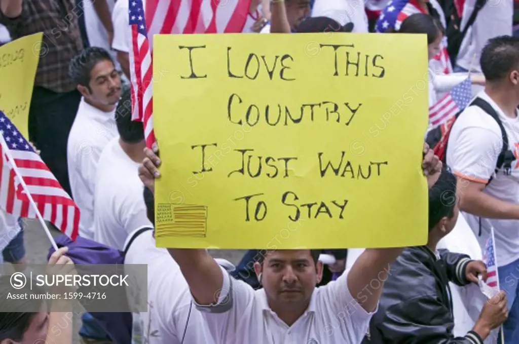 Man holds sign saying 'I love this country' along with hundreds of thousands of immigrants participating in march for Immigrants and Mexicans protesting against Illegal Immigration reform by U.S. Congress, Los Angeles, CA, May 1, 2006