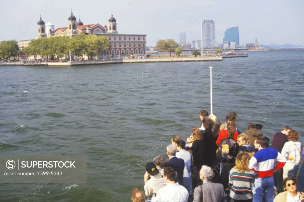 Tourists in boat viewing Ellis Island National Park, New York City, New York