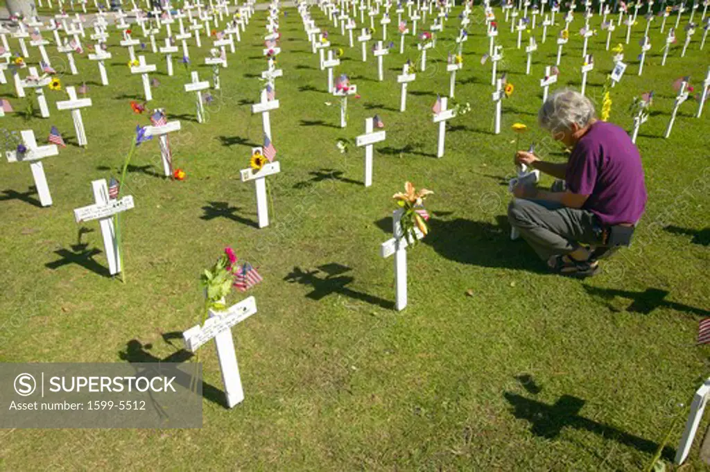 Woman kneels at mock cemetery honoring 1500+ Iraqi servicemen killed in Iraq War, Ventura California