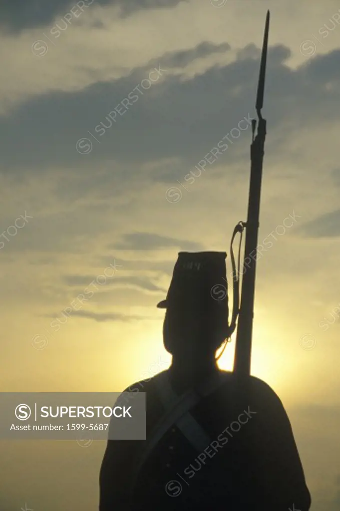 Silhouette of soldier at sunset with gun during reenactment of Battle of Manassas marking the beginning of the Civil War
