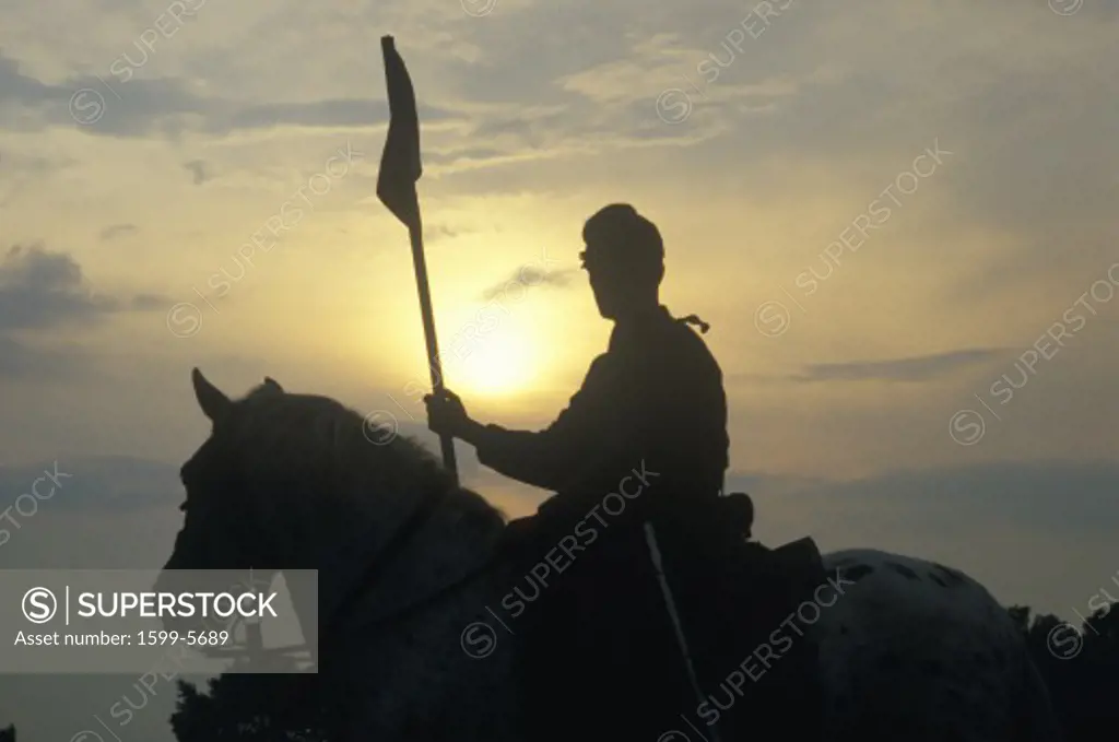 Silhouette of soldier on horseback with  gun during reenactment of Battle of Manassas marking the beginning of the Civil War
