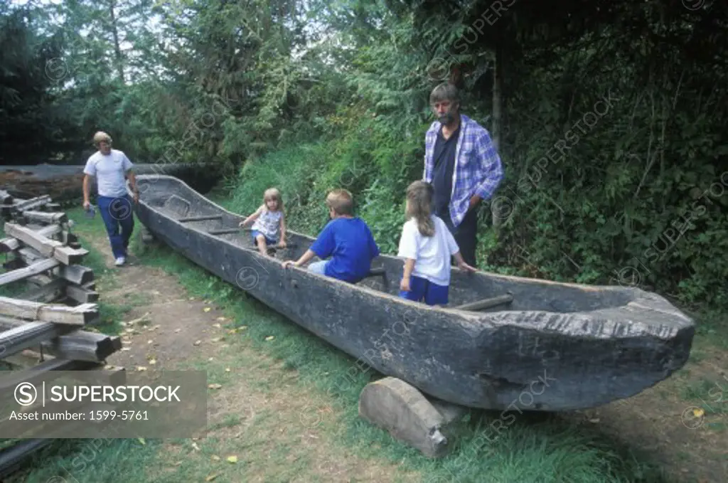 Tourists explore replica of dugout canoe at the Lewis and Clark expedition headquarters of the Fort Clatsoo National Memorial