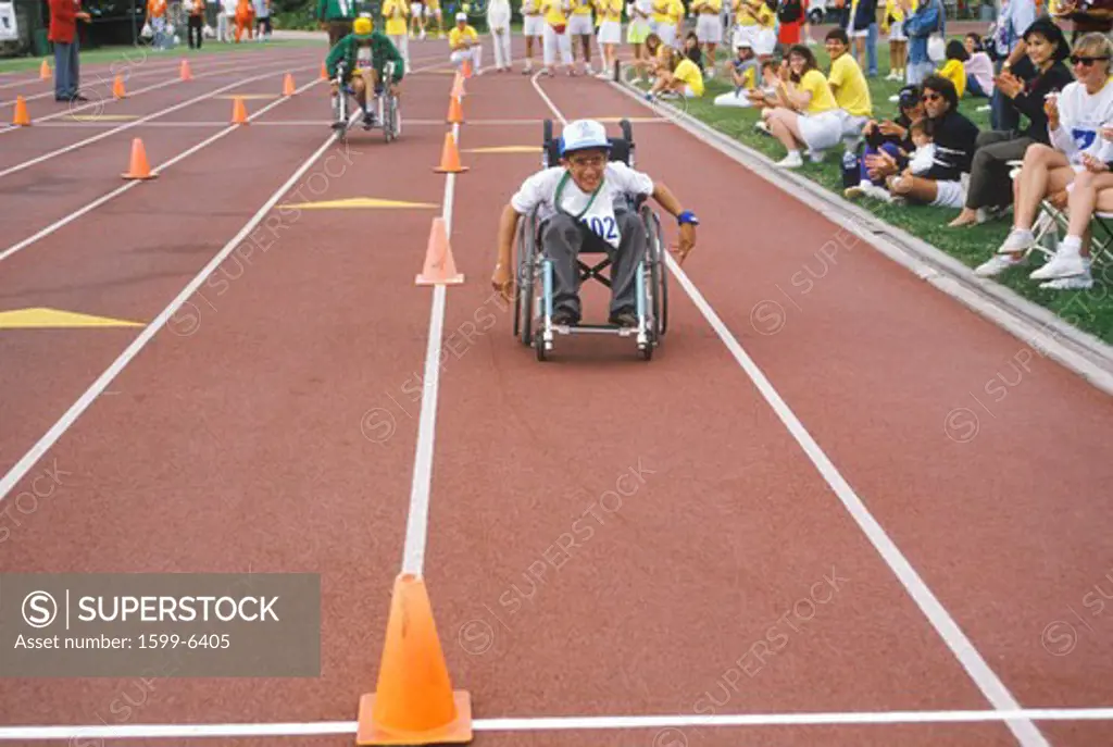 Wheelchair Special Olympics athlete competing in race, approaching finish line, UCLA, CA