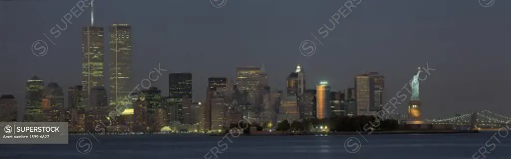 This is the downtown Manhattan skyline and Statue of Liberty. It is the view from New Jersey at dusk. The World Trade towers dominate the left hand side, the Statue of Liberty is on the right.