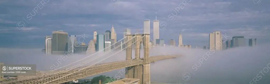 This is the Brooklyn Bridge over the East River with the Manhattan skyline behind it. There is a morning fog enveloping the bridge and make it look like the Emerald City in the Land of Oz. 