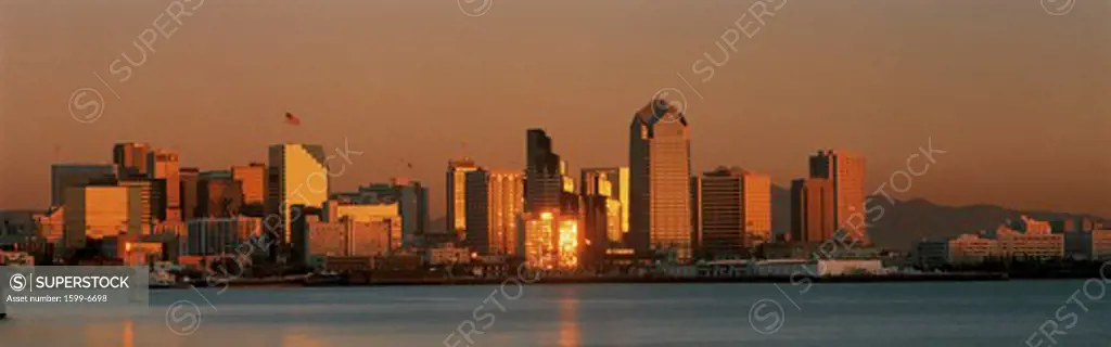 This is the San Diego skyline with the bay in front at sunset. The reflected light on the buildings is golden.
