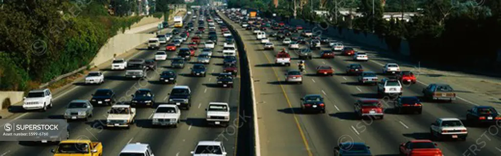 This is rush hour traffic on the 405 Freeway at sunset. There are 10 total lanes of traffic with cars traveling in both directions.