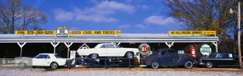 This is a vintage used car dealer along Route 44. It is the former Old Route 66. It is a true piece of Americana. There is a vintage Mustang and a white vintage car on top of a flatbed. Their sign says they sell precious memories.