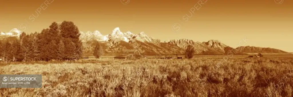 This is Grand Teton National Park in sepiatone. There is a pioneer farm with the Tetons behind it. It is located off Highway 89.