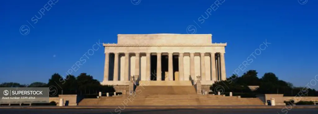 This is the Lincoln Memorial in morning light. We see the wide steps leading up to the columns of the Memorial against a blue sky.