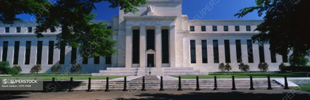 This is the Federal Reserve Bank, also known as The Fed where they make monetary policy. Its Federal Chairman is Alan Greenspan. It is an all white building with a green tree on either side of it. 