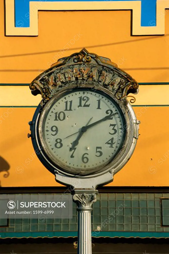 This is a vintage clock in morning light. The time on the clock is 7:11. It has a white face and black hands with silver ornate trim.