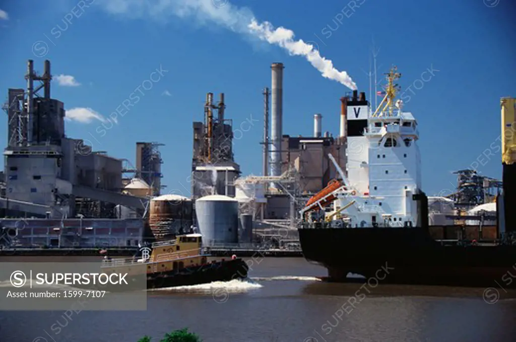 This is a Monrovia cargo ship on the Merkur River and Union Camp Paper Mill loading onto the cargo ship.  It is a paper mill with smokestacks overlooking the river.