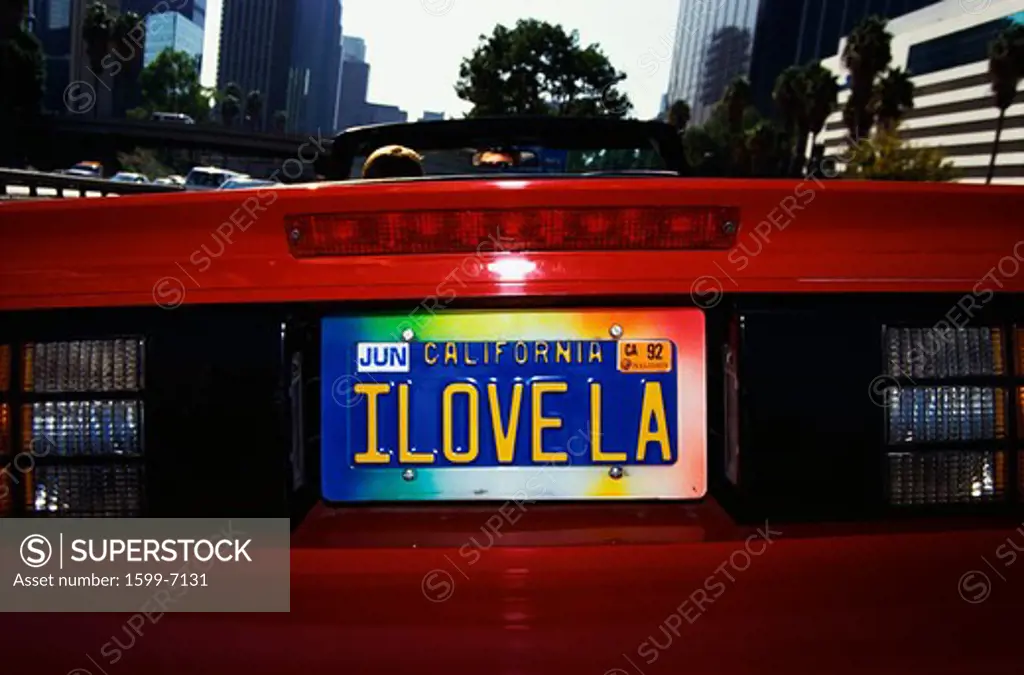 This is a vanity license plate that says, I Love LA. It is on a red convertible sports car.