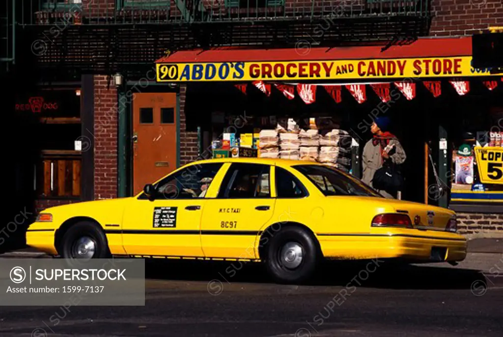 This is a yellow taxi in Greenwich Village parked outside a grocery store.
