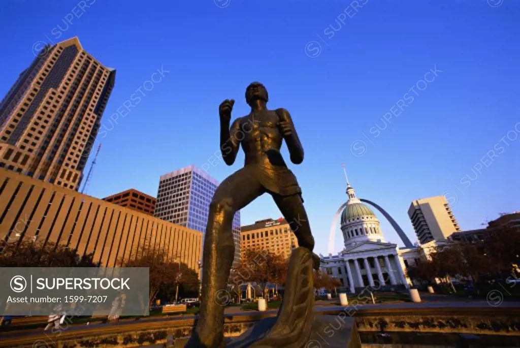This is the Old Courthouse with a close up of the statue in front of the courthouse and State Capitol. In the background is the skyline and arch.
