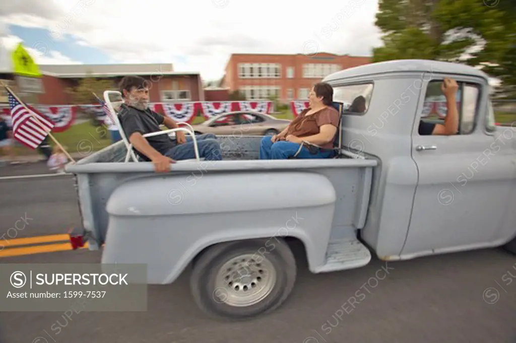 Couple in the back of a pickup truck for the Independence Day Parade, in Lima Montana