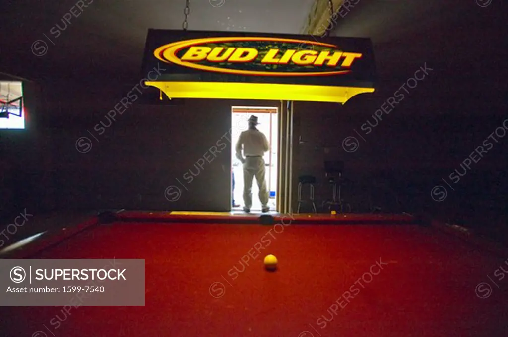Silhouette of a man in the doorway of a pool hall in Lima Montana