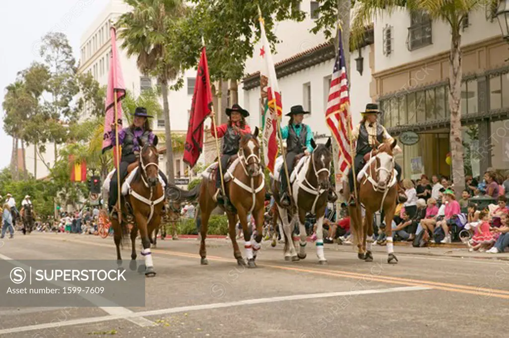 Cowboys marching with American and California flags displayed during opening day parade at annual Old Spanish Days Fiesta held every August in Santa Barbara, California