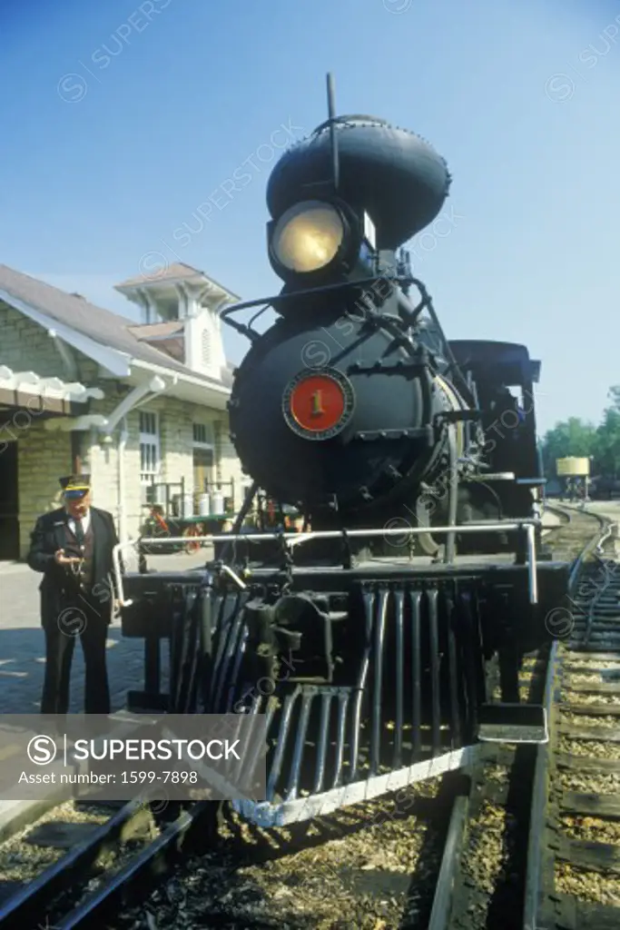 A steam engine conductor as he stands near the cowcatcher on the front, Eureka Springs, Arkansas