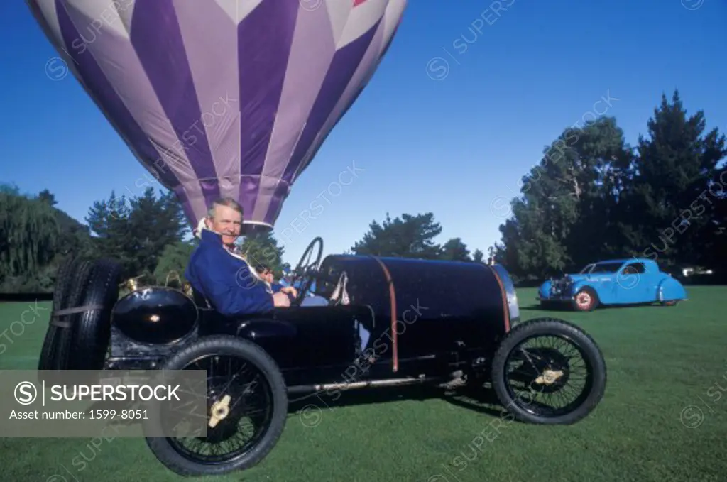 A navy blue Bugatti car and hot air balloon at the 35th Annual Concours D' Elegance Competition in Carmel, CA