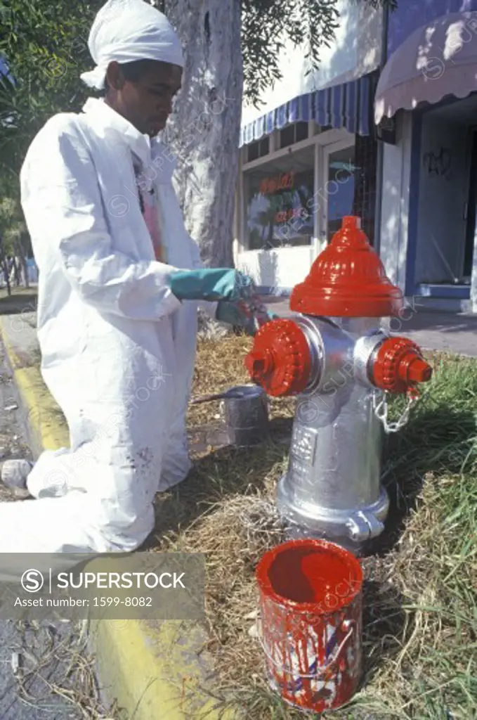 A man painting a fire hydrant in South Beach Miami, Florida