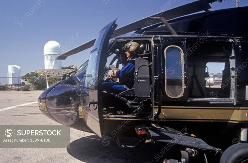 A pilot sitting in the cockpit of the Night Hawk helicopter used by the U.S. Customs Department at a Kitt Peak, Arizona, heliport