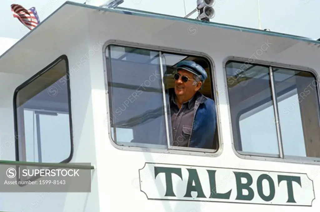 The pilot of the Oxford Ferry looking out the window of his bridge, Chesapeake Bay, Maryland