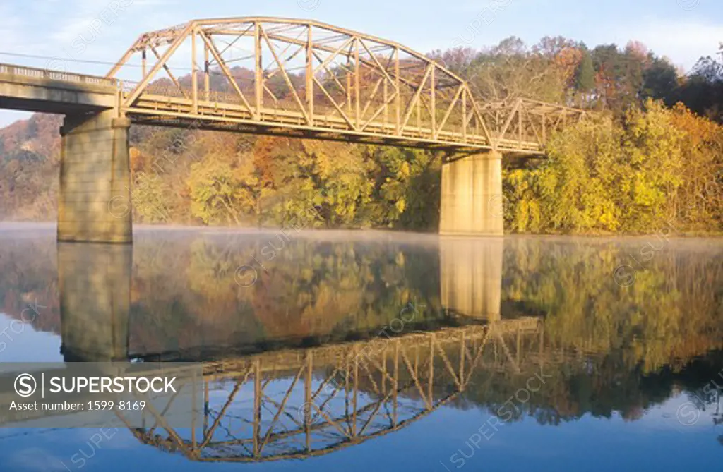 An arched bridge and autumn trees reflected in a river, Tennessee