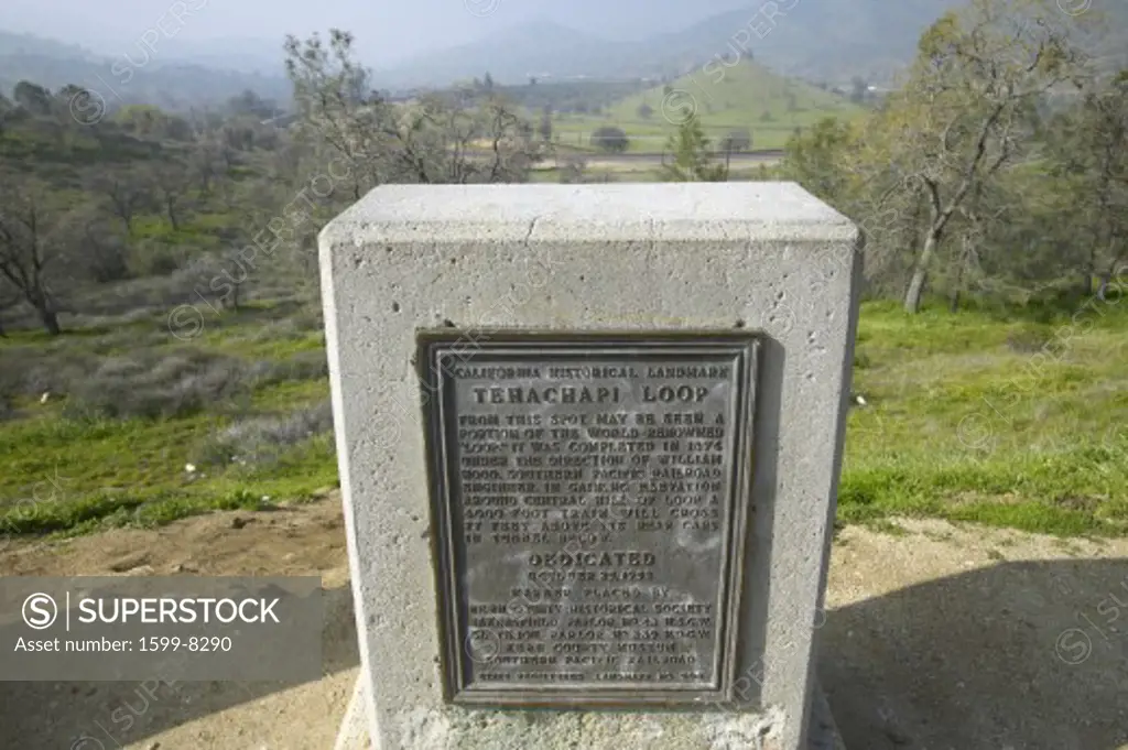 A monument sign from 1955 showing the Tehachapi Train Loop near Tehachapi California is the historic location of the Southern Pacific Railroad where freight trains gain 77 feet in elevation and show freight cars traveling in giant loop