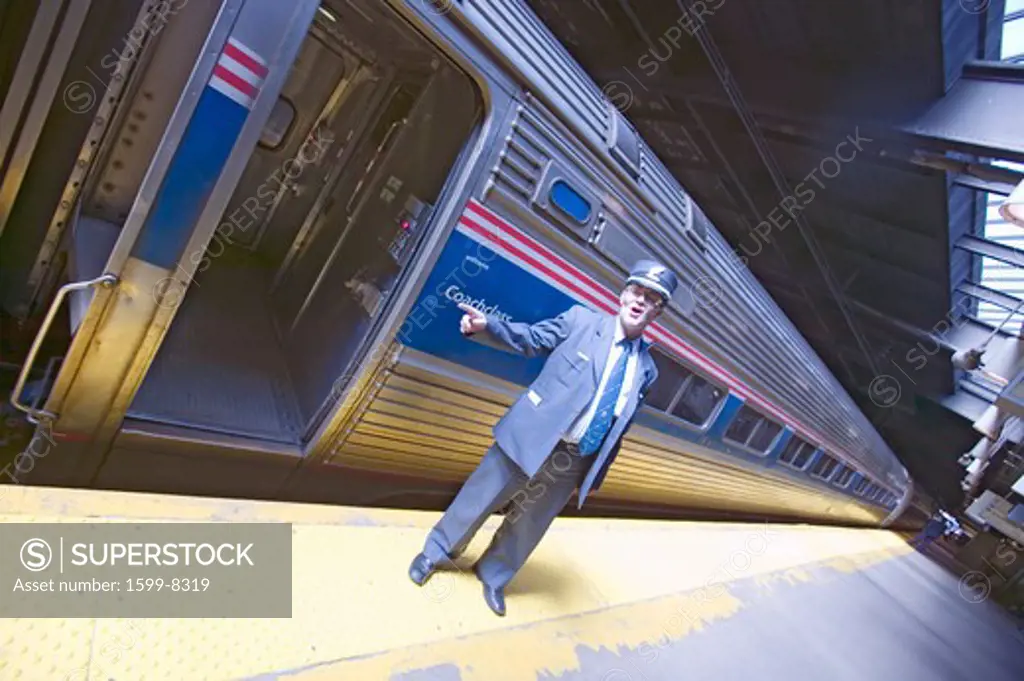 Angled view of conductor at Amtrak train platform announces 'All Aboard' at East Coast train station on the way to New York City, New York, Manhattan, New York